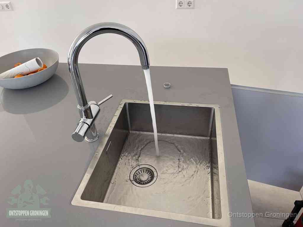 Een vrij doorstromende rvs spoelbak waar het water moeiteloos wegloopt, het resultaat van slim onderhoud dat geld bespaart in Groningen