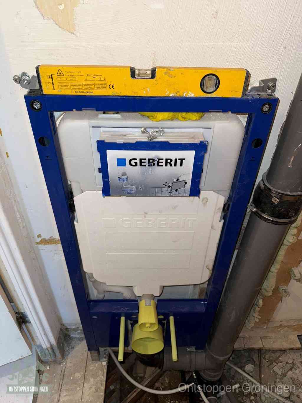 Een Geberit inbouwreservoir met frame voor een hangtoilet tegen de wand, met de afvoerbocht naar de vloer, kenmerkend voor een verstopt hangtoilet in Groningen