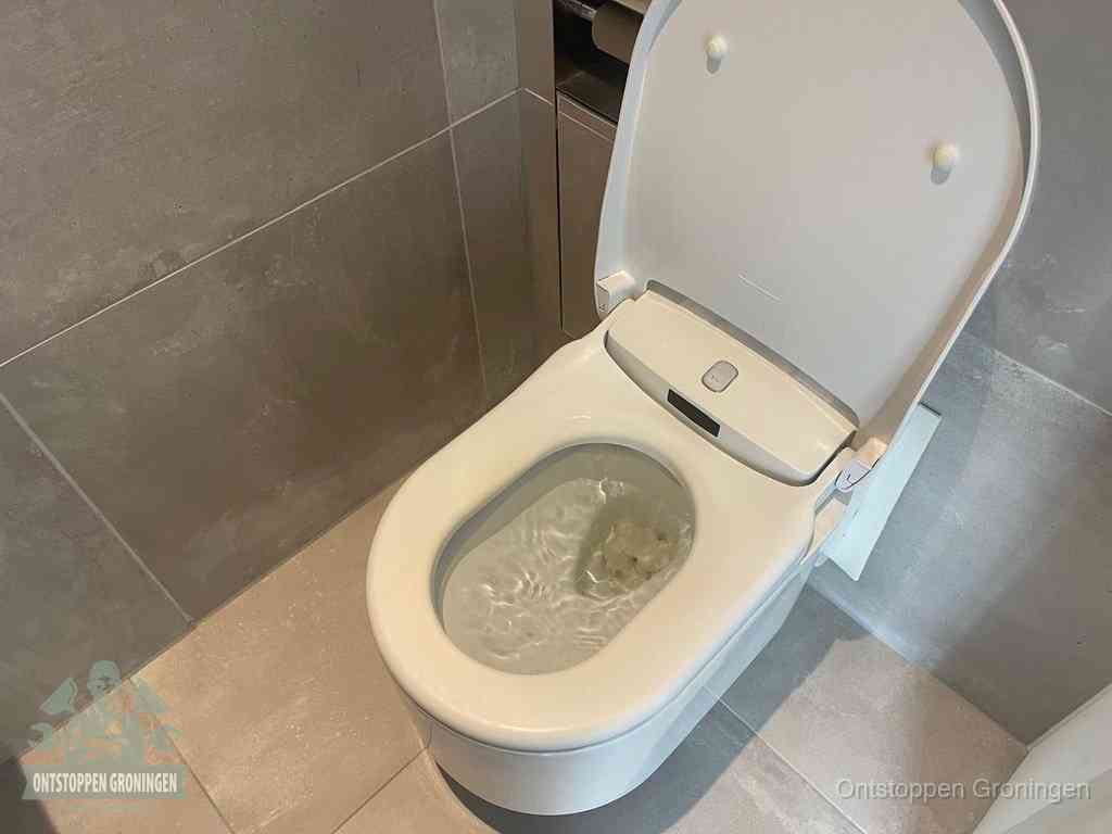 Een toiletpot vol troebel water met drijvend papier en restanten, de meest voorkomende oorzaak van een verstopte wc in Groningen